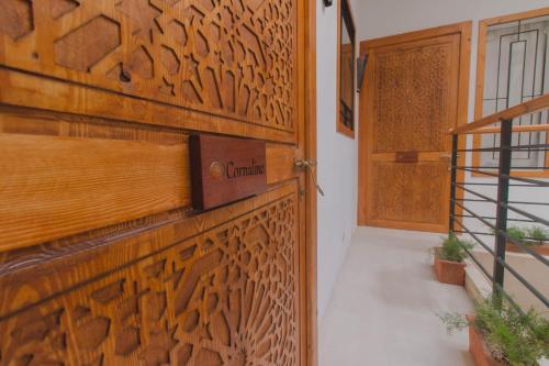 a room with a wooden door with a sign on it at Riad Le Khan Mogador in Essaouira