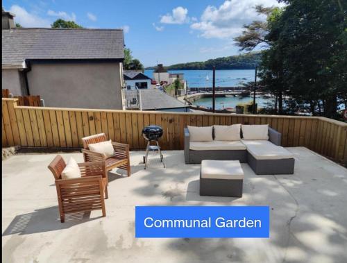 a patio with a couch and chairs and a grill at Crow's Nest Glandore - 4 - Self Catering in Glandore