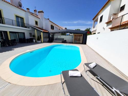 a swimming pool in the backyard of a house at Milfontes Guest House - Duna Parque Group in Vila Nova de Milfontes