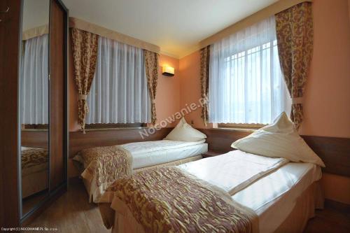 a hotel room with two beds and a window at Dom Gościnny Złota Rybka in Dziwnów