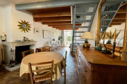 uma sala de jantar com uma mesa e uma lareira em House Rétaise With Garden Close To The Sea em La Couarde-sur-Mer