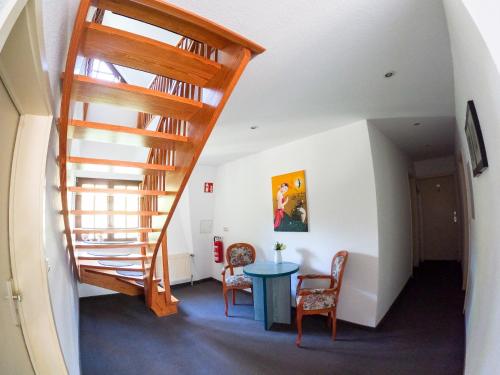 a staircase in a room with a table and chairs at Hotel Diana in Schönwalde