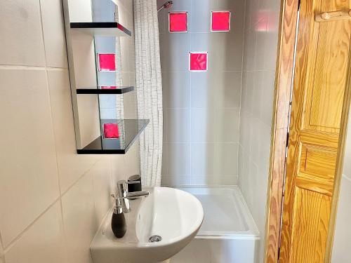 une salle de bain avec un lavabo et une baignoire dans l'établissement Grand studio sur la Marine, à Sète