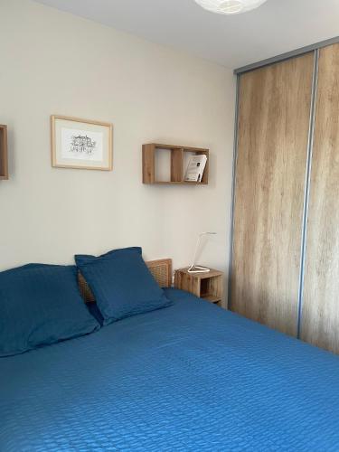 - une chambre avec un lit bleu et une porte coulissante dans l'établissement Superbe appartement T3 proche de la garrigue, à Castries