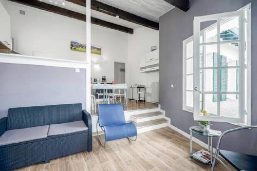 un salon avec un canapé et une chaise bleue dans l'établissement LOCBASQUE-COM - BEGIAK URAN - Villa Les Yeux Dans L'eau 3 ETOILES - WIFI, à Saint-Jean-de-Luz