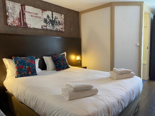 sypialnia z dużym łóżkiem z ręcznikami w obiekcie SHELDER Hôtel - CHERBOURG EN COTENTIN - Equeurdreville w mieście Cherbourg en Cotentin