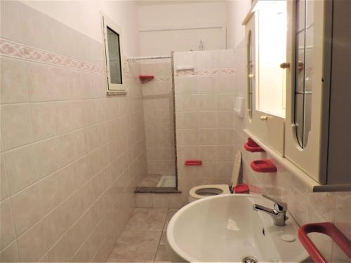 Baño blanco con lavabo y aseo en Residenza Su Portu, en Orosei
