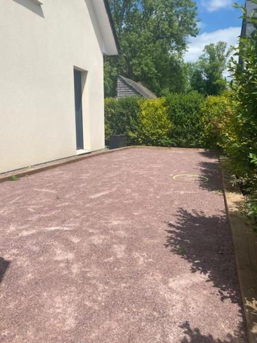 uma entrada em frente a uma casa branca em Maison chaleureuse au calme em Roumare