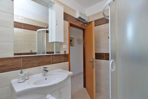 ein Badezimmer mit Waschbecken und Spiegel in der Unterkunft Apartments Mira 615 in Rovinj