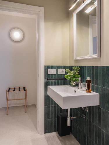 a bathroom with a white sink and a mirror at Living u HomeSuites in Lecce