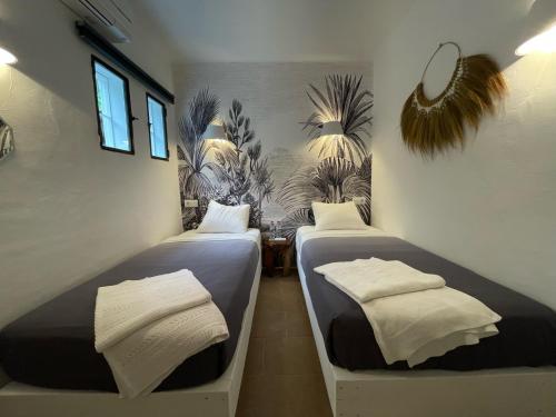 two beds in a room with plants on the walls at Ipunga Ibiza - Adults only in Cala Llonga