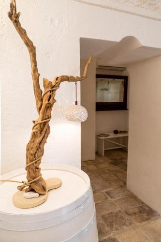 a tree stump sitting on top of a barrel with a hat at MASSERIA SCALEDDA in Manduria