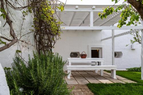 a white bench sitting on a patio in a yard at MASSERIA SCALEDDA in Manduria