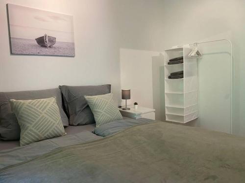 - une chambre avec un lit et une étagère dans l'établissement Central Apartment Flensburg, à Flensbourg