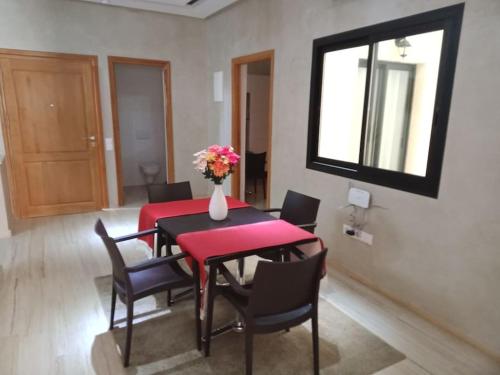 a dining room with a red table and chairs at Suites Appartement Midelt in Midelt