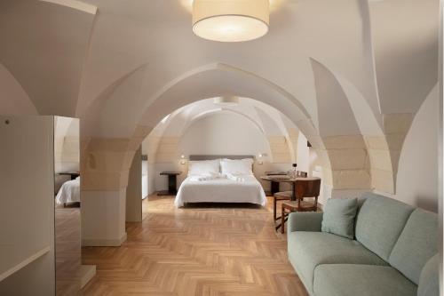 una camera con letto e divano di Palazzo dei Tolomei a Lecce