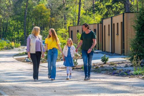 a family walking down a road with a child at EuroParcs Beekbergen in Beekbergen