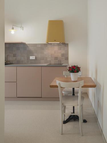 a kitchen with a table and a chair with a potted plant at Living u HomeSuites in Lecce