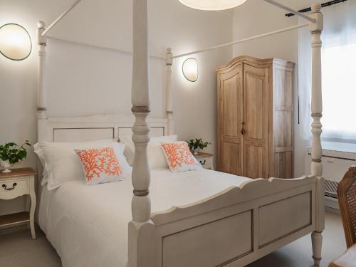 - une chambre avec un lit blanc et une armoire en bois dans l'établissement Living u HomeSuites, à Lecce