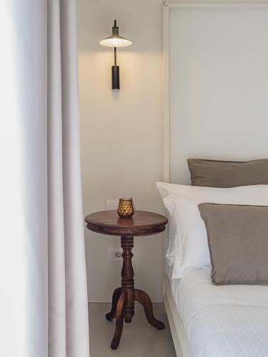 a small table sitting next to a bed with a bed gmaxwell gmaxwell gmaxwell at Living u HomeSuites in Lecce