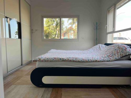 een bed in een kamer met een raam bij אחוזת היניבים Yaniv Estate in Nurit