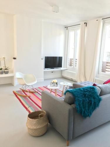 a living room with a couch and a tv at Bright City Design House! in Antwerp