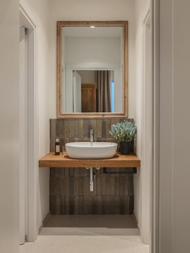 a bathroom with a sink and a mirror at Living u HomeSuites in Lecce