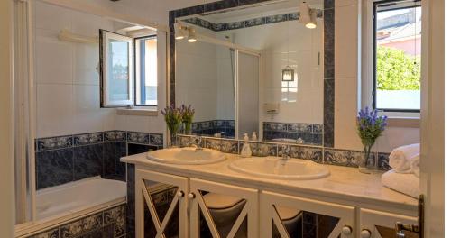 辛特拉的住宿－Villa da Praia，浴室设有2个水槽、浴缸和镜子
