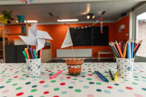 a table topped with three buckets filled with pens and pencils at EuroParcs Beekbergen in Beekbergen