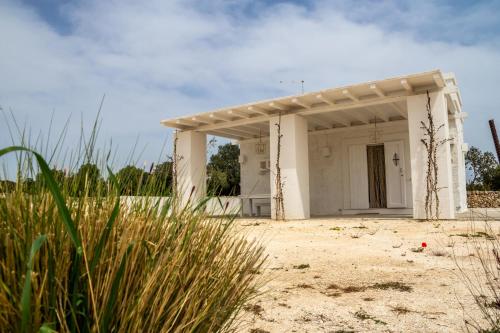a small white building in the middle of a field at MASSERIA SCALEDDA in Manduria