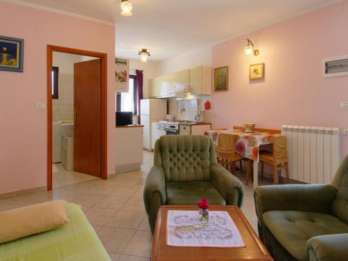 ein Wohnzimmer mit einem Sofa und einem Tisch sowie eine Küche in der Unterkunft Apartment Laganis in Plovanija