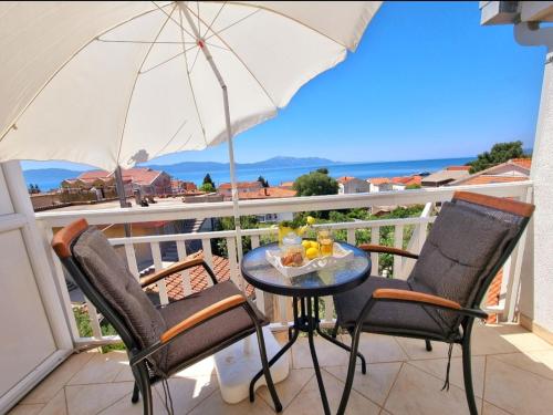 d'une table et de chaises sur un balcon avec un parasol dans l'établissement Vila Damir, à Gradac