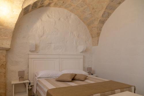 a bedroom with a bed in a white room at MASSERIA SCALEDDA in Manduria