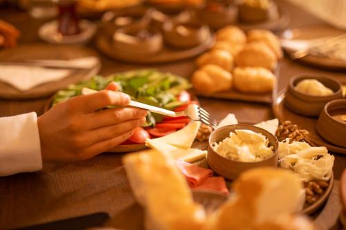 a person sitting at a table with a plate of food at Kayata Cave Suites Special Class in Urgup