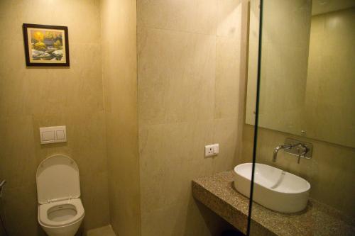 a bathroom with a toilet and a sink at Four Leaf Service Suites, Haridwar in Roorkee
