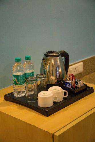 a tray with a tea kettle and water bottles on a counter at Four Leaf Service Suites, Haridwar in Roorkee