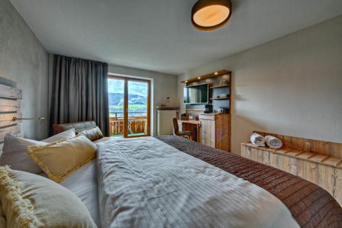 a bedroom with a large bed and a balcony at Allgäuer Panoramahotel in Oberstaufen