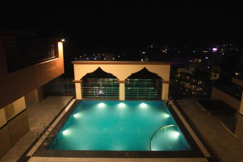 a swimming pool on top of a building at night at Arogyadham Wellness Retreat in Rishīkesh
