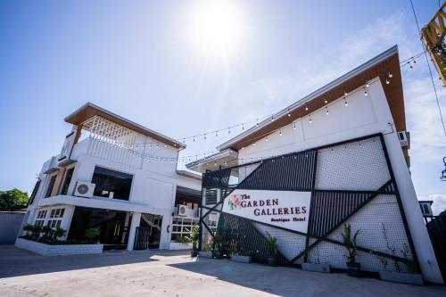 a white building with a gate in front of it at The Garden Galleries Boutique Hotel in Pilar