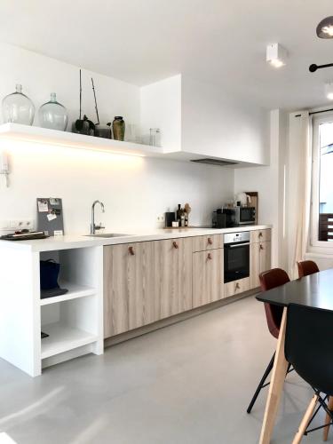 a kitchen with white cabinets and a table at Bright City Design House! in Antwerp
