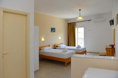 a hotel room with two beds and a window at The Student & Travellers Inn in Athens