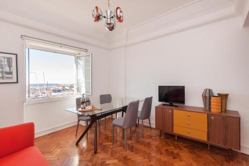 uma sala de estar com uma mesa de jantar e uma televisão em Graça - Castle | Lisbon Cheese & Wine Apartments em Lisboa