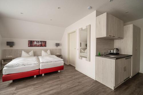 a bedroom with a red and white bed and a sink at Pension Walkmühle in Sangerhausen