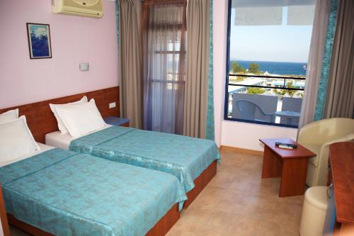 a hotel room with two beds and a balcony at Dunav Hotel in Sunny Beach