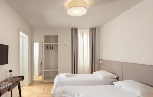 a hotel room with two beds and a desk at Palazzo dei Tolomei in Lecce