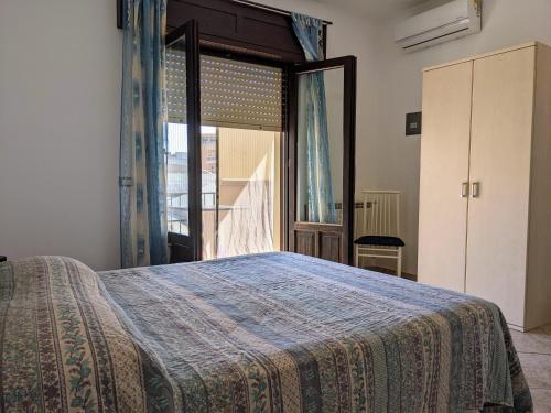 a bedroom with a bed and a large window at B&B A Casa di Angela in Trapani