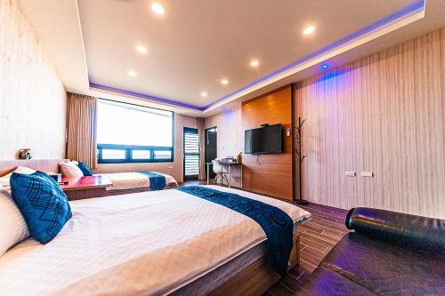 a hotel room with two beds and a flat screen tv at 旅途之家 in Suao