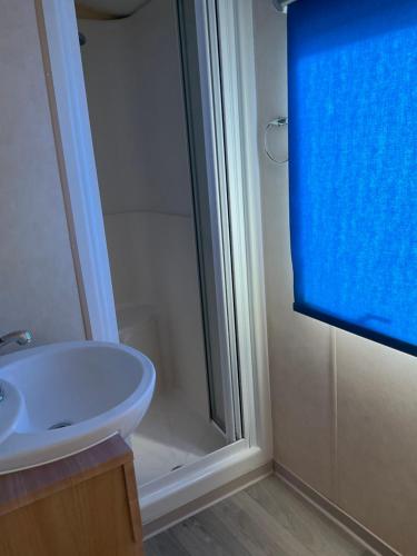 une salle de bain avec un lavabo et une douche dans l'établissement Mobilhome Coup de Coeur, à Sigean