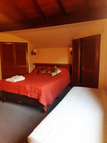 1 dormitorio con 2 camas con sábanas rojas y ventanas en Hotel Duclout Confort Inn en Monte Grande
