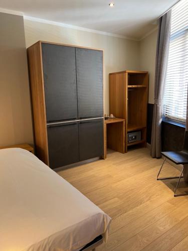 Un dormitorio con una cama, un armario y una silla. en Boardhousing, en Lovaina